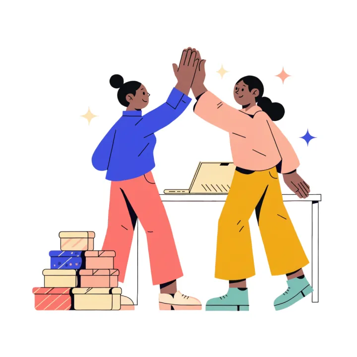 Two colleagues giving each other a high-five beside a stack of parcels ready to ship.